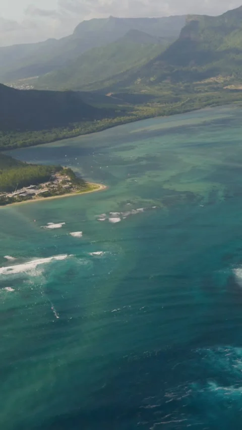 Dramatic mountain peaks rise above turquoise lagoon on Mauritius, sandy Stock Footage 346791167