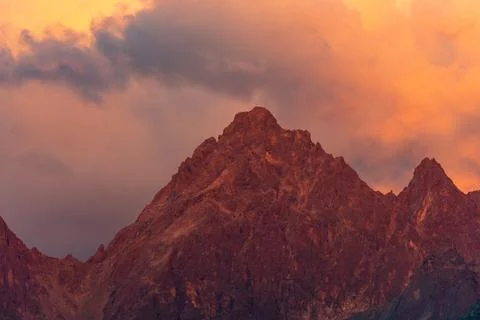 Dramatic Mountain Peaks at Sunset With Orange Sky and Rocky Silhouette Stock Photos