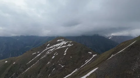 Dramatic mountain peaks under cloudy sky Stock Footage 345387919