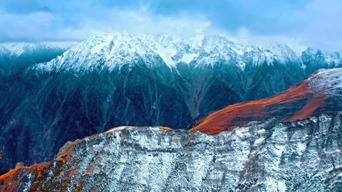 Dramatic mountain range aerial view snow capped peaks rocky cliffs dramatic Stock Footage 343696695