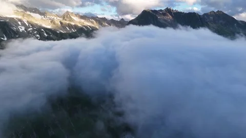 Dramatic Mountain Range Emerging Above Thick Clouds under Scenic Sky Stock Footage 314980198