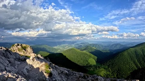 Dramatic mountain range timelapse with moving clouds, sunbeams lighting green Video stock 313593812
