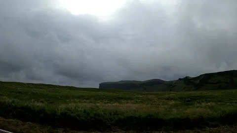 Dramatic mountain ridges and green meadows under stormy sky, Iceland Stock-Footage 334336104