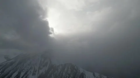 Dramatic mountain scene with clouds rolling in, camera pans across landscape Video stock 319437424