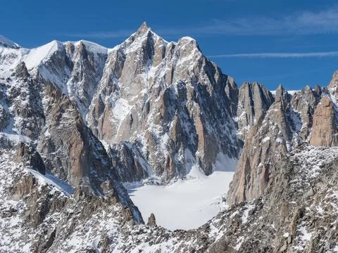 A dramatic mountain scene with jagged peaks and pinnacles snowcapped Stock Photos