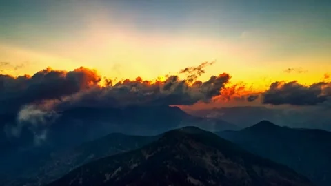 Dramatic mountain sunset with colorful clouds moving over dark peaks time-l.. Stock Footage 341135823