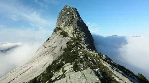 Dramatic mountain surrounded by cloud inversion, drone shot Stock Footage 289576571