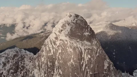 Dramatic Mountain Terrain. Snowy Mountain Peak. Cloudy Winter Sunset. Aerial. BC Stock Footage 255921717