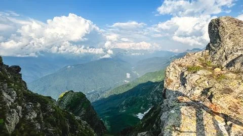 Dramatic Mountain Valley View with Rocky Cliffs and Forested Peaks Stock Photos