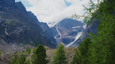 Dramatic mountain vista with snowy ridges and forested slopes Stockbeeldmateriaal 333101656