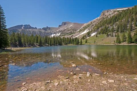 Dramatic Mountains Rising Over an Alpine Lake Stockfoto's