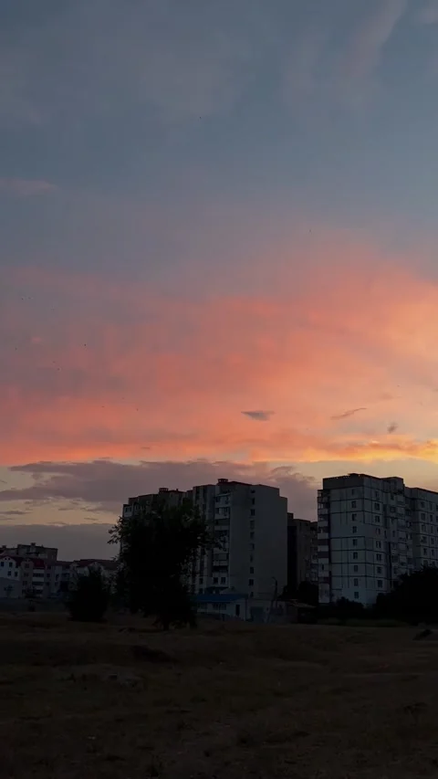 Dramatic multicolored cloudy sky above dark silhouettes of city buildings. Stock Footage 234979119