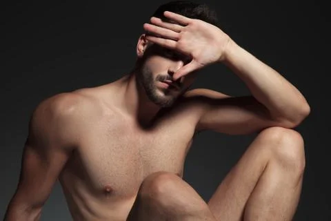 Dramatic naked cool guy avoiding light Stock Photos