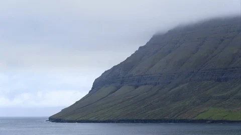 Dramatic narrow fjords covered with low clouds in Faroe Islands.	 Stock Footage 123831757