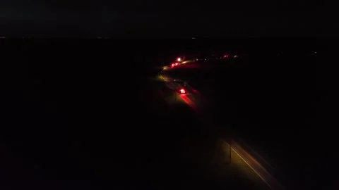 Dramatic night aerial of a dark rural American road lit by emergency vehicles Stock-Footage 312246421