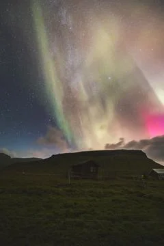 Dramatic night sky with aurora borealis, the Milky Way, and incoming clouds a Foto stock