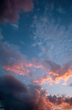 Dramatic night sky, with moon and sun bathing the clouds with light, long Stock Photos