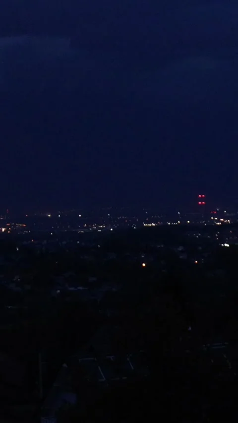 Dramatic night thunderstorm sky above cityscape with dark clouds and glowin.. Stock Footage 313451854