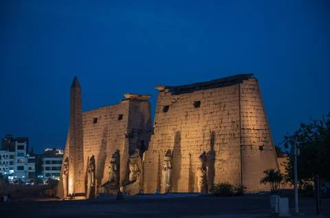A dramatic nighttime image of the main entrance pylon at Luxor Temple in Luxo Фото
