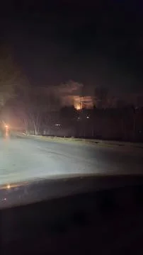 Dramatic nighttime view from inside a vehicle shows bright headlights illumi Stock Photos