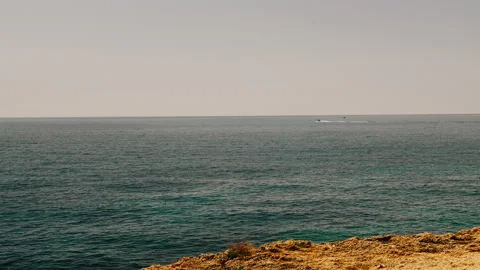Dramatic ocean cliffs sea caves and tourist boats in Algarve Portugal Stock Footage 336730933