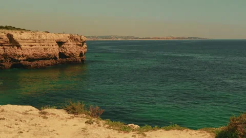Dramatic ocean cliffs sea caves and tourist boats in Algarve Portugal Stock-Footage 336731025
