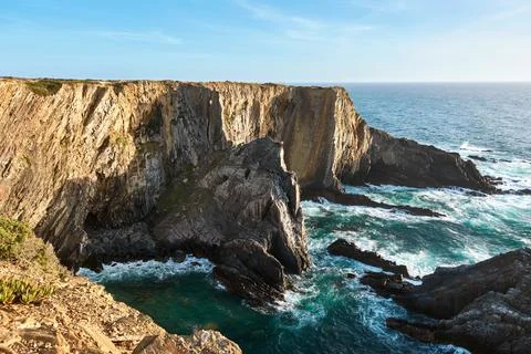 Dramatic ocean cliffs with turquoise waves crashing below Stock Photos