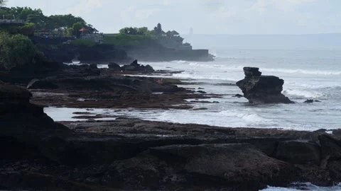 Dramatic Ocean Landscape Featuring Layered Cliffs And Distant Shrine Stock Footage 332617236
