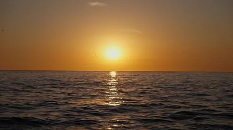 Dramatic ocean sunset. Burning sky and shining golden waves. Sunset sea 4k. Red Stock Photos