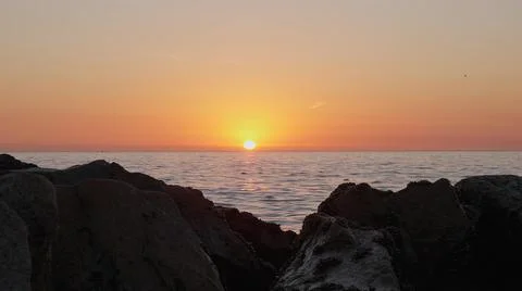 Dramatic ocean sunset. Burning sky and shining golden waves hit rocks. Sunset Stock Photos