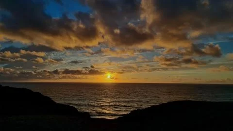 Dramatic Ocean Sunset with Clouds and Cliffs Stock Photos