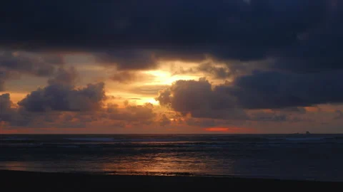Dramatic Ocean Sunset with Dark Clouds and Golden Light Reflecting on Waves. Stock Footage 338361954