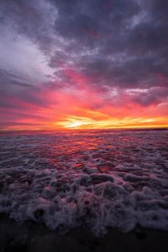 Dramatic Ocean Sunset with Dark Clouds and Vibrant Sky Stock Photos
