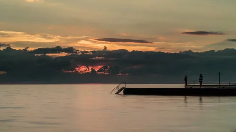 Dramatic Ocean Sunset Pier Timelapse with Silhouetted Figures Stock Footage 344058703
