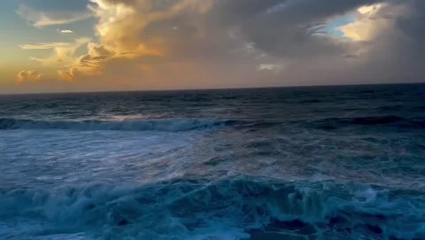Dramatic ocean sunset with rolling waves and golden clouds Vidéo 334084796