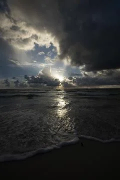 Dramatic Ocean Sunset with Storm Clouds and Sun Rays Stock Photos