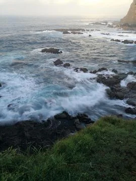 Dramatic ocean view with misty waves and rugged rock formation Stock Photos