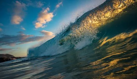 Dramatic Ocean Wave Cresting and Breaking in Golden Sunset Light Stock Photos