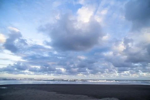 Dramatic Ocean Waves Beneath Towering Coastal Cloudscape Stock Photos
