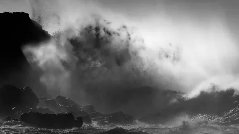 Dramatic ocean waves crash against rocky shore in black and white slow motion Stock Footage 337806433