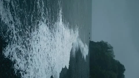 Dramatic ocean waves crashing against rocky cliff, showcasing nature's power and Stock Footage 274703533