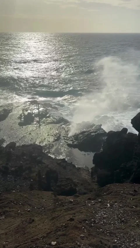 Dramatic ocean waves crashing on dark volcanic rocks with water spray Vidéo 334163558