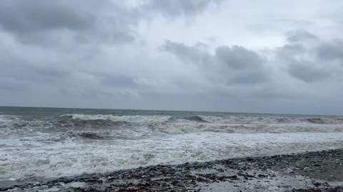Dramatic ocean waves crashing on rocky beach under stormy skies Stock Footage 325518229