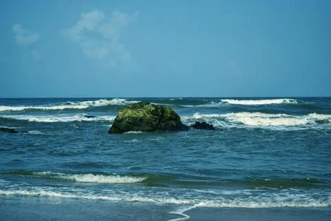 Dramatic Ocean Waves Splashing Against Rocky Shore Sandy Beach Landscape Foto stock