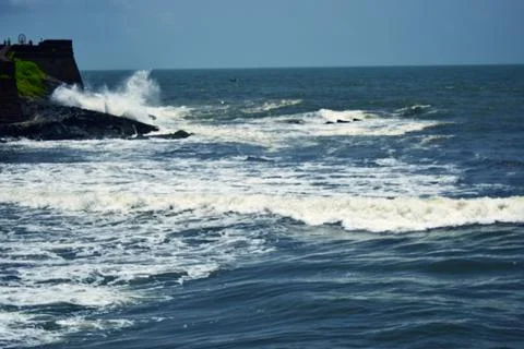 Dramatic Ocean Waves Splashing Against Rocky Shore Sandy Beach Landscape 스톡 사진