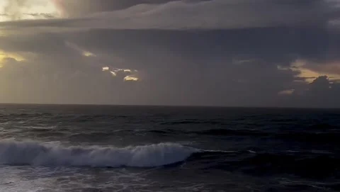 Dramatic ocean waves under a cloudy stormy sky at sunset Vidéo 334084517