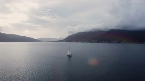 Dramatic ocean. White Sailing yacht sails along bay on cloudy windy day in gap Stock Footage 236187440