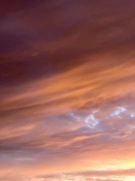 Dramatic Orange and Purple Sunset Sky with Soft Clouds Stockfoto's