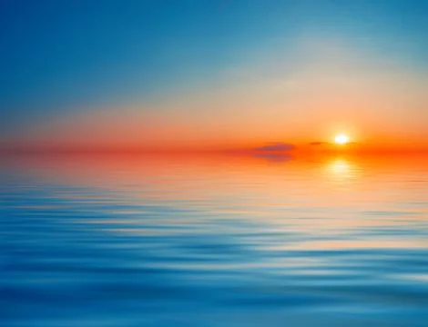 Dramatic orange with blue sky over the water Stock Photos