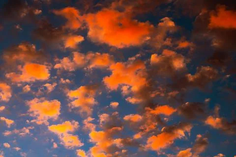 Dramatic orange clouds at sunset. Cloudscape abstract background photo. Stock Photos